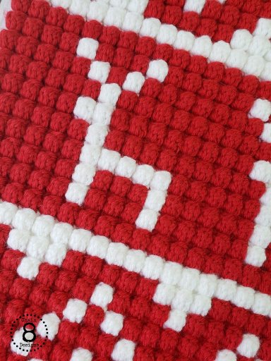 Close-up of red and white crochet reindeer pillow front