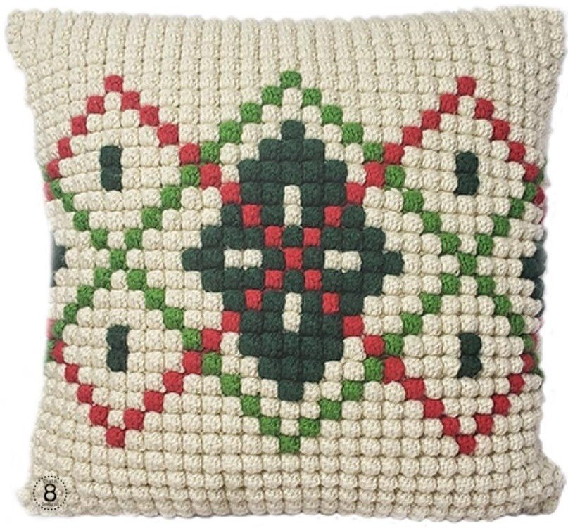 Cream, red, and green argyle patterned Christmas crochet pillow made with the bobble stitch