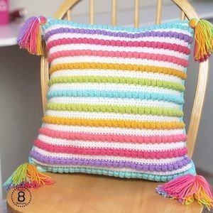 Rainbow striped crochet pillow made using the Bobble Stitch Striped Pillow pattern